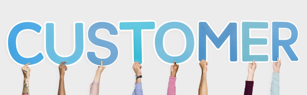 Hands displaying letters for “customer,” highlighting a customer-first approach in CX.